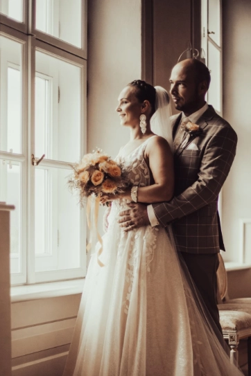 Manželia pozerajú cez okno hradu Slovenská Ľupča.